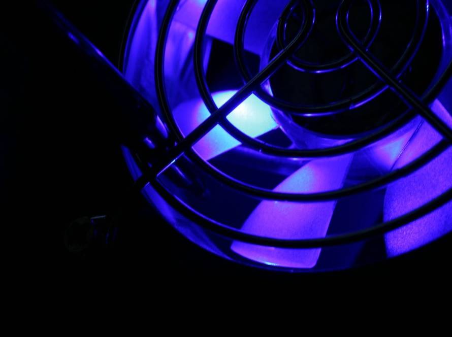 Close-up view of a blue UV light shining on an HVAC cooling fan to reduce mold and bacteria buildup